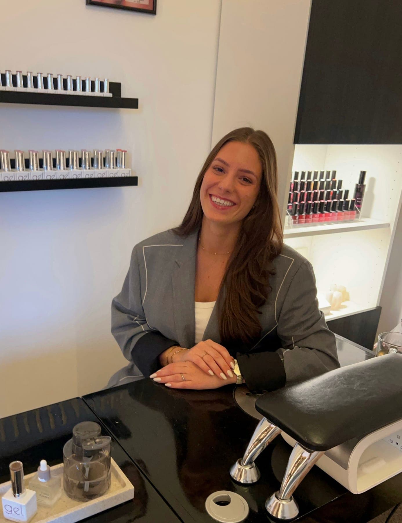 Lynn aan haar werktafel in de salon, met de kleurenrekken op de achtergrond