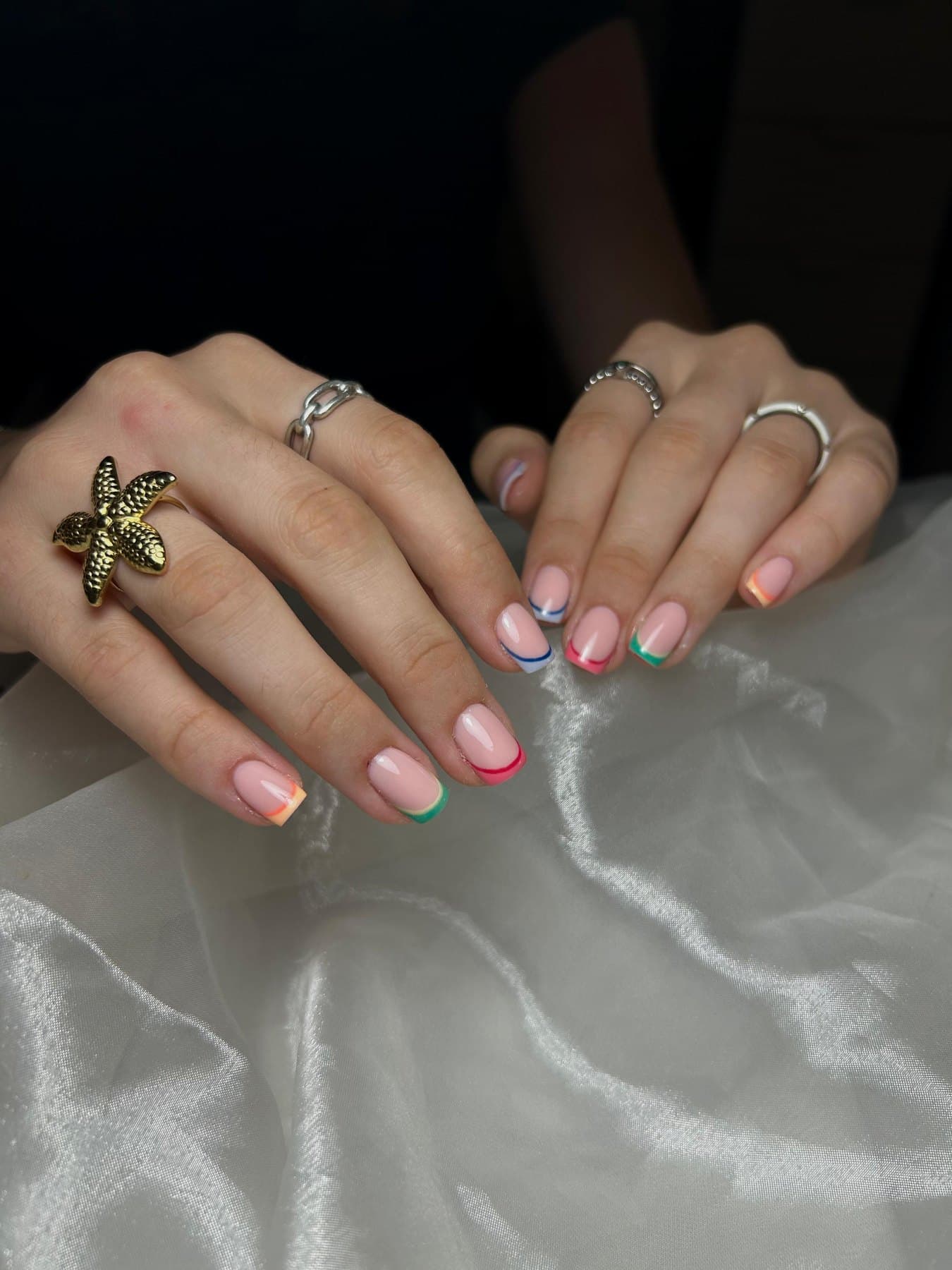 Korte nagels met pastelkleurige french tips in roze, mint en geel