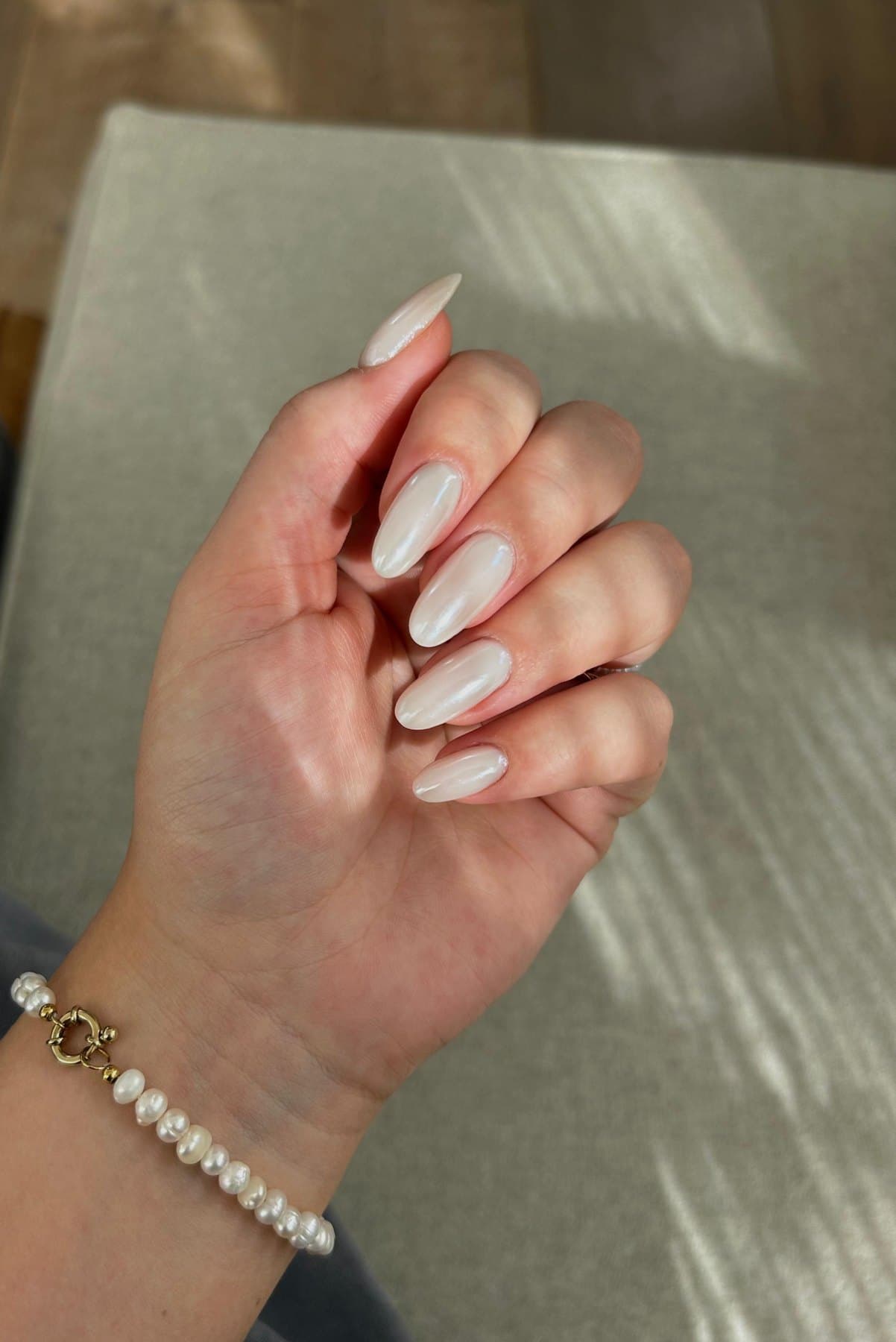 Detailfoto van parelmoerwitte amandelvormige BIAB nagels