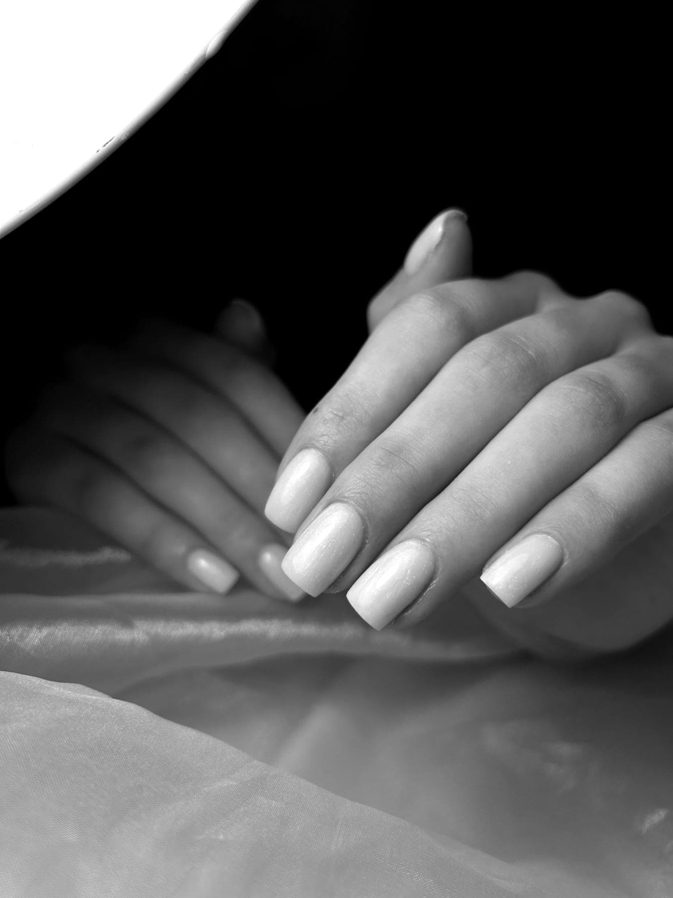 Zwart-witfoto van lange nagels met een zachte parelmoerglans — bekijk op Instagram