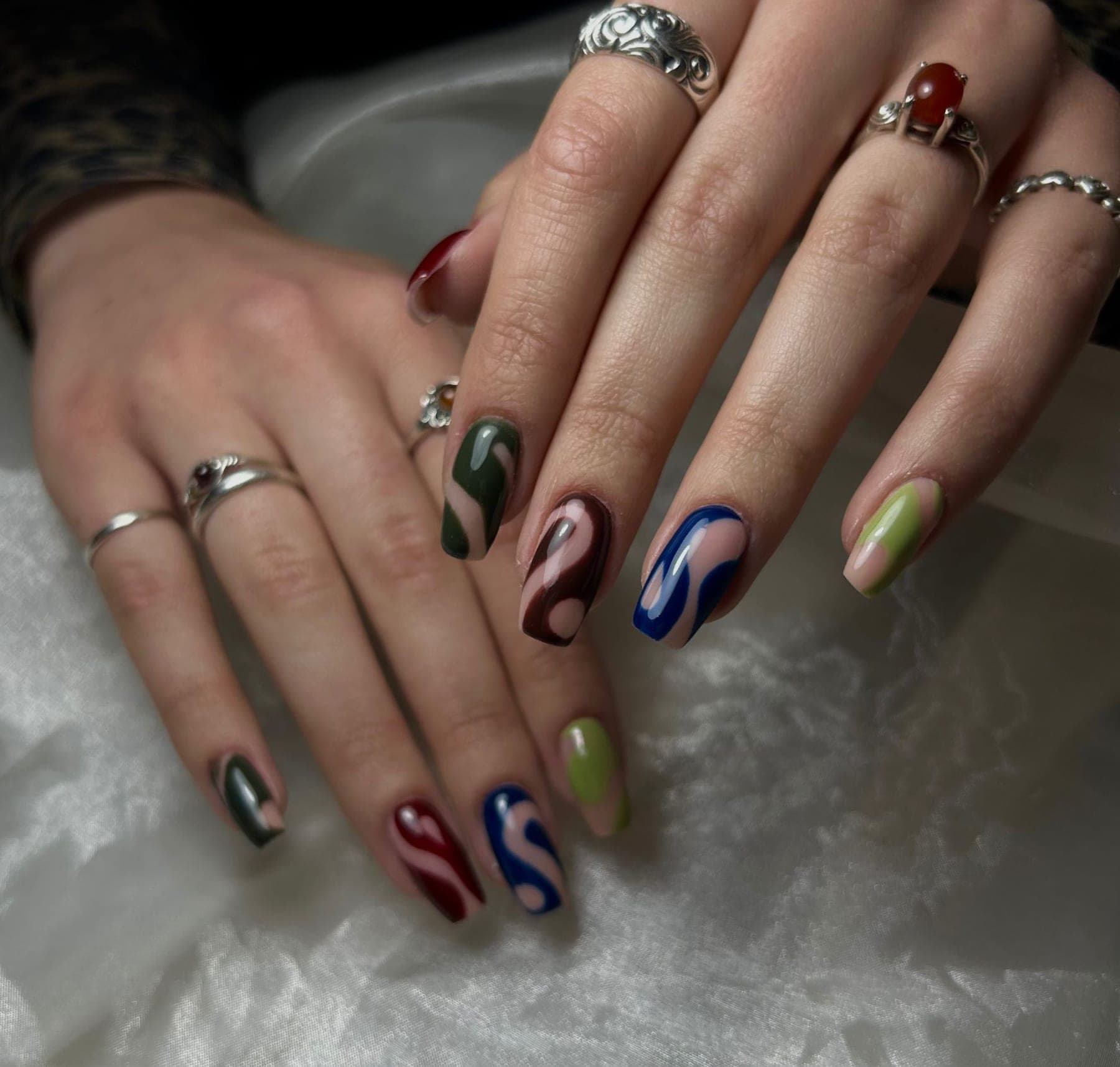 Lange nagels met kleurrijke swirls in groen, blauw en bordeaux — bekijk op Instagram